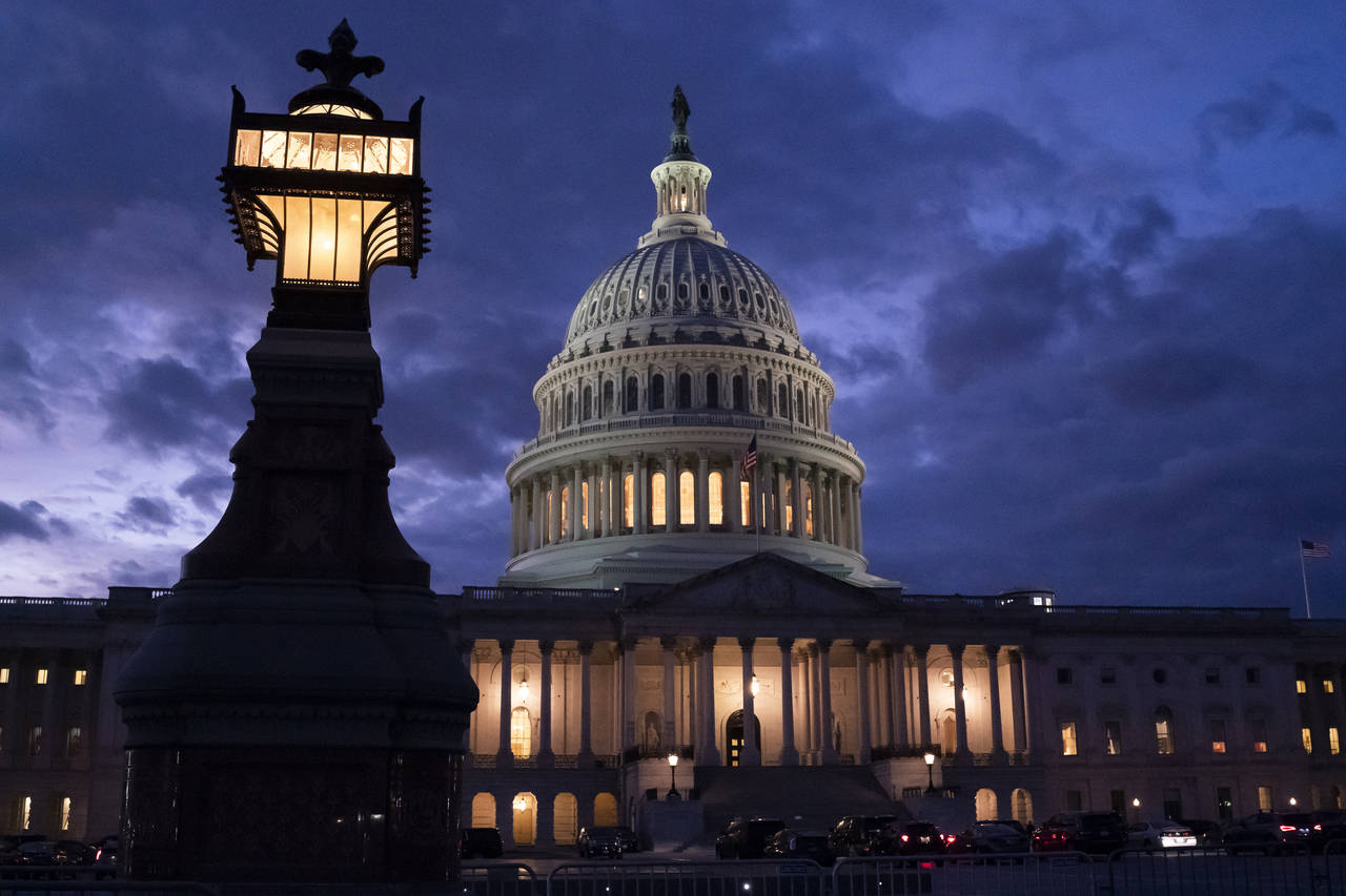 Night falls at the the Capitol in Washington, Thursday, Dec. 2, 2021, with the deadline to fund the...