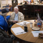 
              Pearl Harbor survivor and World War II Navy veteran David Russell, 101, center, talks with Denise Emery, center left, and other veterans while eating breakfast at the American Legion Post 10 on Monday, Nov. 22, 2021, in Albany, Ore. (AP Photo/Nathan Howard)
            