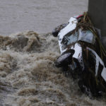 
              A submerged vehicle is wedged against a bridge pillar in the surging Los Angeles River making it difficult for firefighters to access it on Tuesday, Dec. 14, 2021. The vehicle was spotted in the river before dawn. Rain is drenching Southern California as a powerful storm slides down the state, snarling traffic and raising the threat of mudslides in areas scarred by wildfires. (AP Photo/Damian Dovarganes)
            