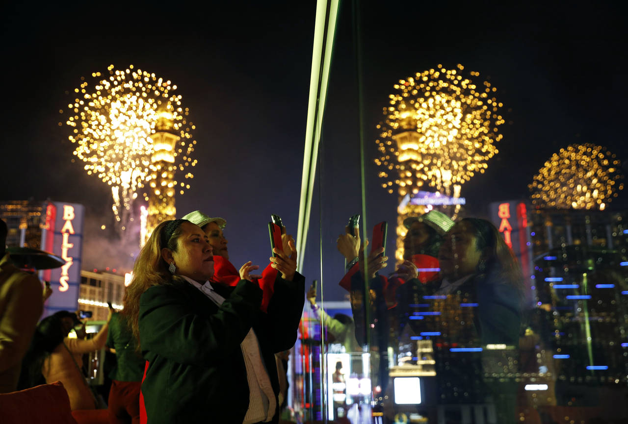 FILE - Revelers watch at Drai's nightclub as fireworks explode on the Las Vegas Strip during a New ...
