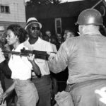 
              FILE - Gloria Richardson, head of the Cambridge Nonviolent Action Committee, pushes a National Guardsman's bayonet aside as she moves among a crowd of African Americans to convince them to disperse in Cambridge, Md., on July 21, 1963. Richardson, an influential yet largely unsung civil rights pioneer whose determination not to back down while protesting racial inequality was captured in a photograph as she pushed away the bayonet of a National Guardsman, died July 15, 2021, in New York. (AP Photo/File)
            