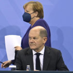 
              German Chancellor Angela Merkel, background, and Finance Minister Olaf Scholz arrive for a press conference following a meeting with the heads of government of Germany's federal states at the Chancellery in Berlin, Thursday, Dec. 2, 2021. Merkel said Thursday that people who aren't vaccinated will be excluded from nonessential stores, cultural and recreational venues, and parliament will consider a general vaccine mandate, as part of an effort to curb coronavirus infections that again topped 70,000 newly confirmed cases in a 24-hour period. (John Macdougall/Pool Photo via AP)
            