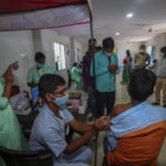 
              A health worker administers COVID-19 vaccine as other await the turn in Hyderabad, India, Thursday, Dec. 2, 2021. (AP Photo/Mahesh Kumar A.)
            