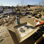 
              A framed photo of Martha Thomas lies among the debris of her destroyed home in the aftermath of tornadoes that tore through the region several days earlier, in Mayfield, Ky., Monday, Dec. 13, 2021. (AP Photo/Gerald Herbert)
            