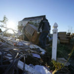 
              Chad Thomas and his best friend Dave Courtney salvage possessions for Chad's mother's destroyed home, in the aftermath of tornadoes that tore through the region, in Mayfield, Ky., Monday, Dec. 13, 2021. (AP Photo/Gerald Herbert)
            