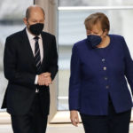 
              FILE - German Chancellor Angela Merkel, right, and SPD candidate for chancellor Olaf Scholz talk during a parliament Bundestag session about new measures to battle the coronavirus pandemic at the Reichstag building in Berlin, Germany, Nov.18, 2021. Germany's outgoing Chancellor Angela Merkel and her likely successor met with state governors to consider tighter rules to curb coronavirus infections. The rise in COVID-19 cases over the past weeks and the arrival of the new omicron variant have prompted warnings from scientists and doctors that medical services in the country could become overstretched in the coming weeks unless drastic action is taken. (AP Photo/Markus Schreiber, File)
            