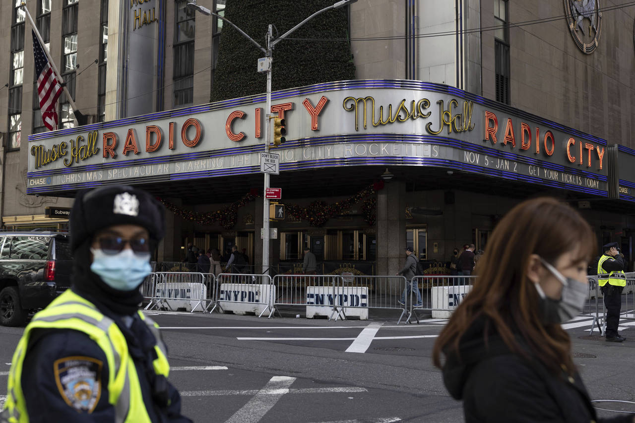 People stand in front of Radio City Music Hall after cancellations of The Rockettes performance due...