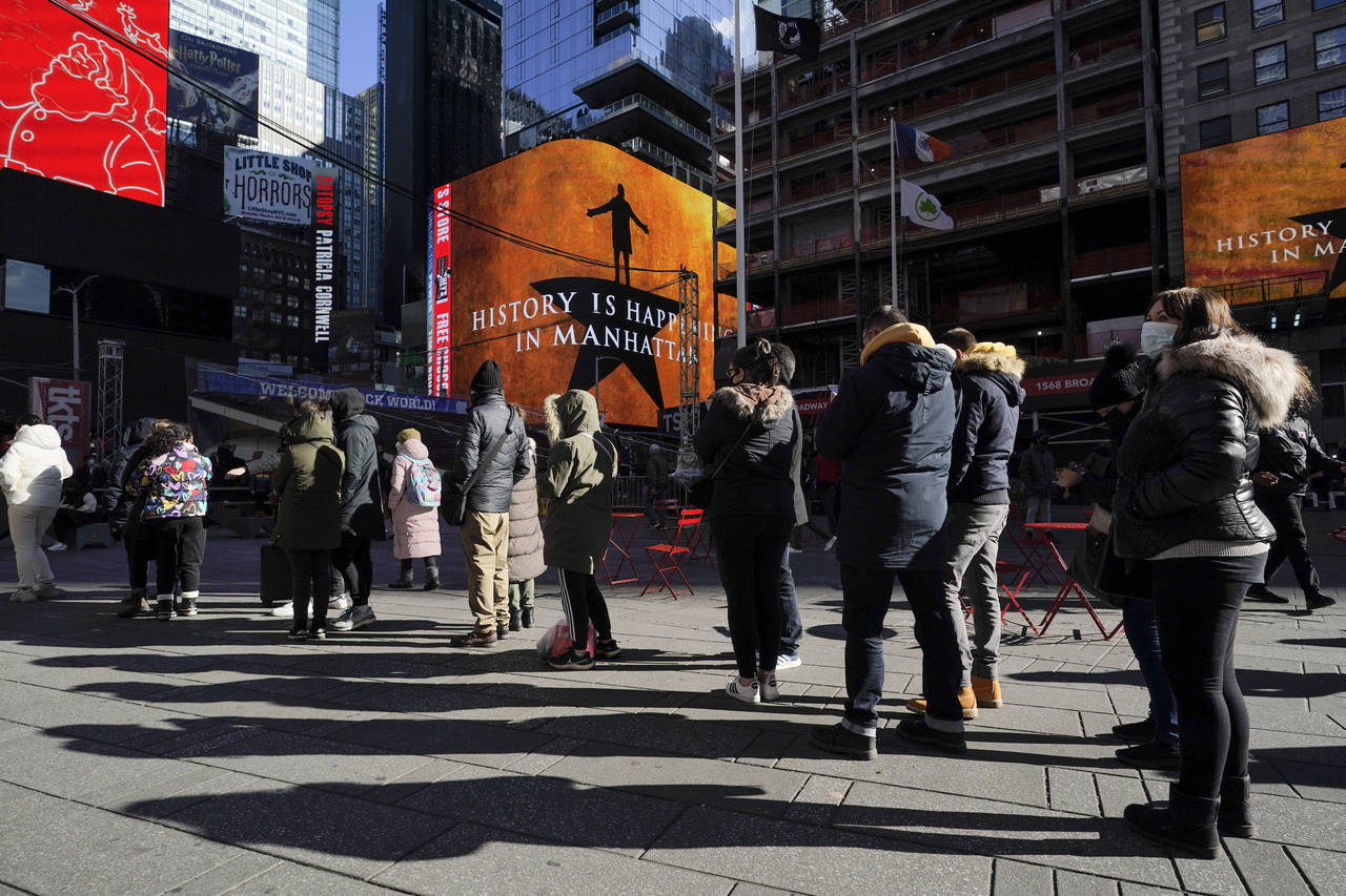 People wait in a long line to get tested for COVID-19 in Times Square, New York, Monday, Dec. 20, 2...