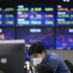 
              A currency trader watches computer monitors near the screens at a foreign exchange dealing room in Seoul, South Korea, Wednesday, Dec. 1, 2021. Asian shares were mixed Wednesday amid nervous trading due to worries over the newest coronavirus variant.  (AP Photo/Lee Jin-man)
            