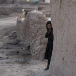 
              FILE - An Afghan girl looks out of her house in Kamar Kalagh village near Herat, Afghanistan, on Nov. 27, 2021. The United Nations is predicting that a record 274 million people – who together would amount to the world’s fourth most-populous country – will require emergency humanitarian aid next year in countries including Afghanistan, Ethiopia, Myanmar, Syria and Yemen as they face a raft of challenges such as war, insecurity, hunger, climate change and the coronavirus pandemic. (AP Photo/Petros Giannakouris, File)
            