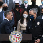 
              Joined by business owners and community leaders, Los Angeles Mayor Eric Garcetti, left, and Police Chief Michel Moore shake hands during a news conference outside the Los Angeles Police Headquarters in Los Angeles, Thursday, Dec. 2, 2021. Authorities in Los Angeles on Thursday announced arrests in recent smash-and-grab thefts at stores, part of a rash of organized retail crime in California. (AP Photo/Jae C. Hong)
            