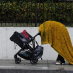 
              A homeless person shields themselves from the rain under a wet cover in downtown Los Angeles Tuesday, Dec. 14, 2021, in Los Angeles. A powerful storm slid south through California on Tuesday, drenching the drought-stricken state with desperately needed rain. (AP Photo/Damian Dovarganes)
            