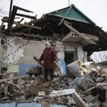 
              Liudmyla Momot weeps as she searches for any still-usable items Friday, Dec. 10, 2021, in the debris of her house in the village of Nevelske in eastern Ukraine, that was struck by a mortar shell fired by Russia-backed separatists. Her village, northwest of the rebel-held city of Donetsk, is only about 3 kilometers (2 miles) from the line of contact between the separatists and the Ukrainian military and has been emptied of all but five people. Small arms fire frequently is heard in the daytime, giving way to the booms of light artillery and mortars after dusk. (AP Photo/Andriy Dubchak)
            