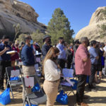 
              FILE - People take part in a naturalization ceremony to become U.S. citizens, May 4, 2021, in Joshua Tree National Park, Calif. While on the brink of furloughing 70% of its roughly 20,000 employees that summer, U.S. Citizenship and Immigration said almost overnight that it would end the year with the large surplus. (AP Photo/Elliot Spagat, File)
            