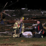 
              Firefighters wait for help to carry out a person who was found in a debris field injured when a tornado ripped a house off its foundation along Highway F at the intersection of Stub Road in St. Charles County, Mo., Friday, Dec. 10, 2021. (David Carson/St. Louis Post-Dispatch via AP)
            