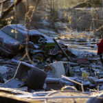 
              Dena Ausdorn stands at the remains of her home after a tornado in Dawson Springs, Ky., Sunday, Dec. 12, 2021. Ausdorn has lived there for 28 years and lost two of her dogs with another left paralyzed after the tornado. (AP Photo/Michael Clubb)
            