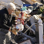 
              Martha Thomas salvages Christmas decorations from her destroyed home in the aftermath of tornadoes that tore through the region, in Mayfield, Ky., Monday, Dec. 13, 2021. (AP Photo/Gerald Herbert)
            