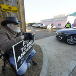
              Mark Godbold, anti-abortion activist, holds a sign calling for prayer to end abortion, as he sits outside the entrance to the parking lot of the Jackson Women's Health Organization, a state-licensed abortion clinic in Jackson, Miss., Wednesday, Dec. 1, 2021. A small group of anti-abortion activists stood outside the clinic in an effort to dissuade patients from entering. On Wednesday, the U.S. Supreme Court hears a case that directly challenges the constitutional right to an abortion established nearly 50 years ago. (AP Photo/Rogelio V. Solis)
            