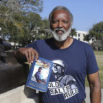 
              Reuben Green, a retired Black Naval officer, poses with the book he authored, "Black Officer, White Navy," at Memorial Park in Jacksonville, Fla., Friday, Feb. 26, 2021. (AP Photo/Gary McCullough)
            