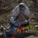 
              A woman worships a wild male elephant , one of two killed by a train in Durung Pathar, in the northeastern Indian state of Assam, Wednesday, Dec. 1, 2021. Speeding trains have run down dozens of wild elephants in Assam in the past, forcing the Indian Railways, which runs the trains, to regulate speed in known elephant corridors. Assam, which has a history of man-elephant conflict, has an estimated 5,000 wild Asiatic elephants. (AP Photo/Anupam Nath)
            
