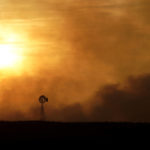 
              A windmill is silhouetted against smoke from a fire that burned and stretched across Ellis, Russell, Osborne and Rooks counties Thursday, Dec. 16, 2021, near Natoma, Kan. Firefighters and emergency responders are battling fires spreading across parts of central and western Kansas after a powerful storm blew through the state. (AP Photo/Charlie Riedel)
            