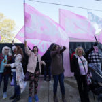 
              The Pink Flags wave their "Jesus" banners in opposition to abortion outside the Jackson Women's Health Organization, a state-licensed abortion clinic in Jackson, Miss., Wednesday, Dec. 1, 2021. A group of anti-abortion activists stood outside the clinic in an effort to dissuade patients from entering. On Wednesday, the U.S. Supreme Court heard a case that directly challenges the constitutional right to an abortion established nearly 50 years ago. (AP Photo/Rogelio V. Solis)
            
