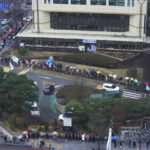 
              People wait for the coronavirus testing outside a public health center in Seoul, South Korea, Wednesday, Dec. 15, 2021. Halting its steps toward normalcy, South Korea will clamp down on social gatherings and cut the hours of some businesses to fight a record-breaking surge of the coronavirus that has led to a spike in hospitalizations and deaths. (AP Photo/Ahn Young-joon).
            