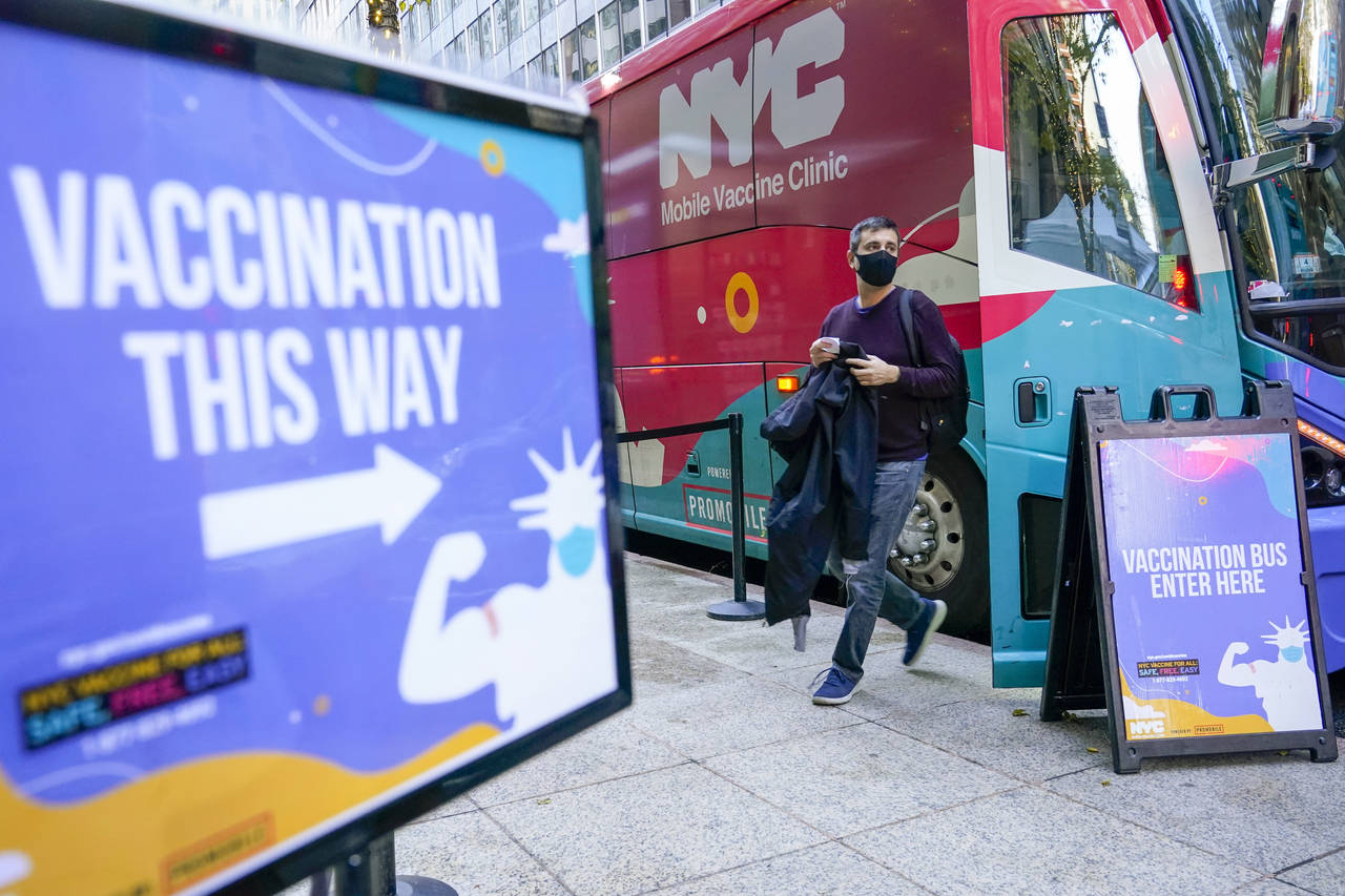 A man walks off a vaccination bus at a NYC mobile vaccine clinic in Midtown Manhattan, Monday, Dec....
