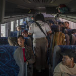 
              Nicaraguan migrant Benjamin Villalta, left, smiles as he and other migrants, mostly Central American, listen to the instructions of an immigration officer after abandoning their journey north, in Ciudad Isla, southern Veracruz state, Mexico, Nov. 25, 2021. The 39-year-old Nicaraguan couldn’t believe that a Mexican immigration office would open in the middle of the night to give him and some 40 other migrants one-year humanitarian visas allowing them to move about Mexico and work. (AP Photo/Felix Marquez)
            