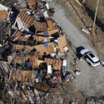 
              In this aerial photo, a person stands next to a destroyed home in the aftermath of tornadoes that tore through the region, in Dresden, Tenn., Sunday, Dec. 12, 2021. (AP Photo/Gerald Herbert)
            