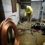 
              A crew breaks the concrete floor as they replace the lead water main with copper tubing at a home in Royal Oak, Mich., on Tuesday, Nov. 16, 2021. Communities with lead pipes could see higher test results for lead in their tap water if a new method of water sampling goes into effect. The Detroit suburb of Royal Oak historically had low test results but it had to notify the public of a problem after the state mandated new sampling methods. (AP Photo/Carlos Osorio)
            
