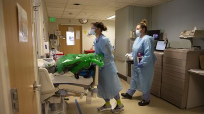 Nurses admit a patient transferred from the ICU COVID unit to the acute care COVID unit at Harborvi...