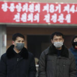 
              People wearing face masks walk on the street near the Pyongyang railway station in Pyongyang, North Korea, Thursday, Jan. 27, 2022. The red banner says, "Implementation of decisions of the Forth Plenary Meeting of the Eighth Central Committee of Workers' Party of Korea." (AP Photo/Cha Song Ho)
            