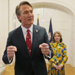 
              Virginia Gov. Glenn Youngkin speaks while his wife, Suzanne, listens after swearing in his Cabinet at the Mansion at the Capitol, Saturday Jan. 15, 2022, in Richmond, Va. (AP Photo/Steve Helber)
            