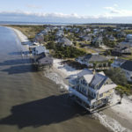
              FILE - Water laps the bottom level of four homes in Harbor Island, S.C., Saturday, Oct. 30, 2021, which had to be abandoned after years of beach erosion and damage from Hurricane Matthew in 2016. Facing state budgets that are flush with cash, Democratic and Republican governors alike want to spend part of their windfalls on projects aimed at slowing climate change and guarding against its consequences, from floods and fires to cleaning up dirty air. (AP Photo/Rebecca Blackwell, File)
            
