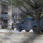 
              Law enforcement teams stage near Congregation Beth Israel while conducting SWAT operations in Colleyville, Texas on Saturday afternoon, Jan. 15, 2022. Authorities said a man took hostages Saturday during services at the synagogue where the suspect could be heard ranting in a livestream and demanding the release of a Pakistani neuroscientist who was convicted of trying to kill U.S. Army officers in Afghanistan. (Lynda M. Gonzalez/The Dallas Morning News via AP)
            