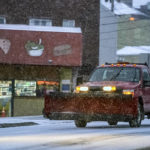 
              A snowplow truck waits at a stoplight on Liberty Avenue as snow falls during a winter storm that will impact the region on Sunday night, Jan. 16, 2022, in Lawrenceville a neighborhood in Pittsburgh. (Alexandra Wimley/Pittsburgh Post-Gazette via AP)
            