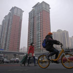 
              People wearing face masks to help protect from the coronavirus cross an intersection in Fengtai District in Beijing, Monday, Jan. 24, 2022. Chinese authorities have lifted a monthlong lockdown of Xi'an and its 13 million residents as infections subside ahead of the Winter Olympics. Meanwhile, the 2 million residents of one Beijing district are being tested following a series of cases in the capital. (AP Photo/Andy Wong)
            