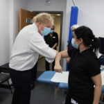 
              Britain's Prime Minister Boris Johnson greets staff, during a visit to Finchley Memorial Hospital, in North London, Tuesday, Jan. 18, 2022. (Ian Vogler, Pool Photo via AP)
            