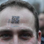 
              A protestor wears a QR code on his forehead during a demonstration against COVID-19 measures in Brussels, Sunday, Jan. 23, 2022. Demonstrators gathered in the Belgian capital to protest what they regard as overly extreme measures by the government to fight the COVID-19 pandemic, including a vaccine pass regulating access to certain places and activities and possible compulsory vaccines.(AP Photo/Geert Vanden Wijngaert)
            