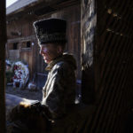 
              A participant, dressed in a traditional costume, leans on a windowsill while celebrating the Malanka festival in the village of Krasnoilsk, Ukraine, Friday, Jan. 14, 2022. Dressed as goats, bears, oxen and cranes, many Ukrainians rang in the new year last week in the colorful rituals of the Malanka holiday. Malanka, which draws on pagan folk tales, marks the new year according to the Julian calendar, meaning it falls on Jan. 13-14. In the festivities, celebrants go from house to house, where the dwellers offer them food. (AP Photo/Ethan Swope)
            