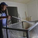 
              FILE - Santiago Nava, a guest migrant worker from Hidalgo, Mexico, who is on his first trip as a seasonal worker, cleans a container at a crab house in Fishing Creek, Maryland, May 14, 2020. Migrants’ incomes in the United States have been helped by labor shortages there. And the fact that a smaller percentage are undocumented than before means more qualified for U.S. pandemic support payments in 2020. (AP Photo/Julio Cortez, File)
            