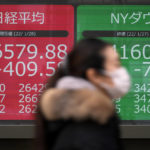 
              A woman wearing a protective mask rides a bicycle in front of an electronic stock board showing Japan's Nikkei 225 and New York Dow indexes at a securities firm Friday, Jan. 28, 2022, in Tokyo. Asian stock markets were mixed Friday as traders looked ahead to data on U.S. employment costs that might influence Federal Reserve decisions on planned interest rate hikes. (AP Photo/Eugene Hoshiko)
            