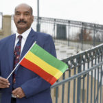 
              Negasi Beyene, who grew up in Mekele, the capital city of the Ethiopia's Tigray Region, holds a traditional Ethiopian flag Saturday, Dec. 18, 2021 in Columbia, Md. Beyene, who works as a biostatistician near Washington, identifies as a human rights activist for Ethiopian unity. “My motto is, ‘humanity before ethnicity.’” (AP Photo/Steve Ruark)
            