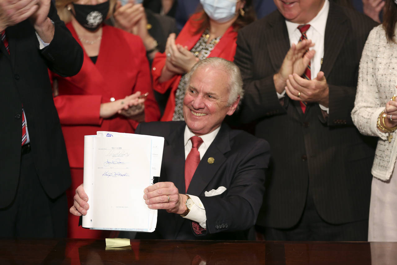 South Carolina Gov. Henry McMaster holds up a bill banning almost all abortions in the state after ...