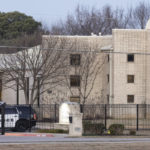 
              Police stand in front of the Congregation Beth Israel synagogue, Sunday, Jan. 16, 2022, in Colleyville, Texas. A man held hostages for more than 10 hours Saturday inside the temple. The hostages were able to escape and the hostage taker was killed. FBI Special Agent in Charge Matt DeSarno said a team would investigate "the shooting incident." (AP Photo/Brandon Wade)
            