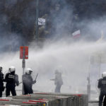 
              Police set off a water cannon against protestors during a demonstration against COVID-19 measures in Brussels, Sunday, Jan. 23, 2022. Demonstrators gathered in the Belgian capital to protest what they regard as overly extreme measures by the government to fight the COVID-19 pandemic, including a vaccine pass regulating access to certain places and activities and possible compulsory vaccines. (AP Photo/Geert Vanden Wijngaert)
            