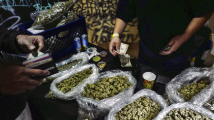 FILE - In this April 15, 2019, file photo, a vendor makes change for a marijuana customer at a cann...