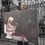 
              Artist Kaya Mar displays his painting of Britain's Prime Minister Boris Johnson as he stands outside Downing Street in London, Wednesday, Jan. 19, 2022. (AP Photo/Kirsty Wigglesworth)
            
