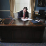 
              FILE - Virginia Gov. Glenn Youngkin works at his desk inside his private office at the State Capitol in Richmond, Va., Jan. 18, 2022. Youngkin has used his first two weeks in office to push Virginia firmly to the right, attempting a dramatic political shift in a state once considered reliably Democratic that's being closely watched by others in the GOP. (Bob Brown/Richmond Times-Dispatch via AP, File)
            